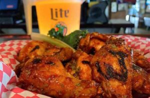 spicy chicken wings with pitcher of beer at sandbar sports grill