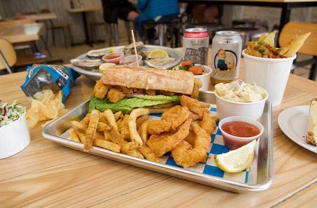 table with multiple drinks and entrees including fried shrimp with sides at st augustine seafood company