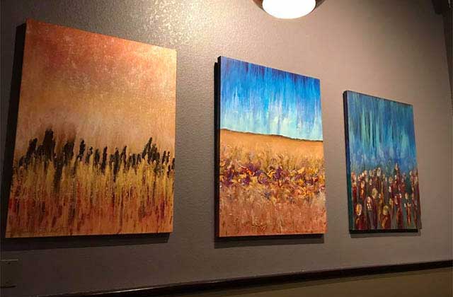 three abstract paintings on a wall at pizza gallery grill melbourne florida