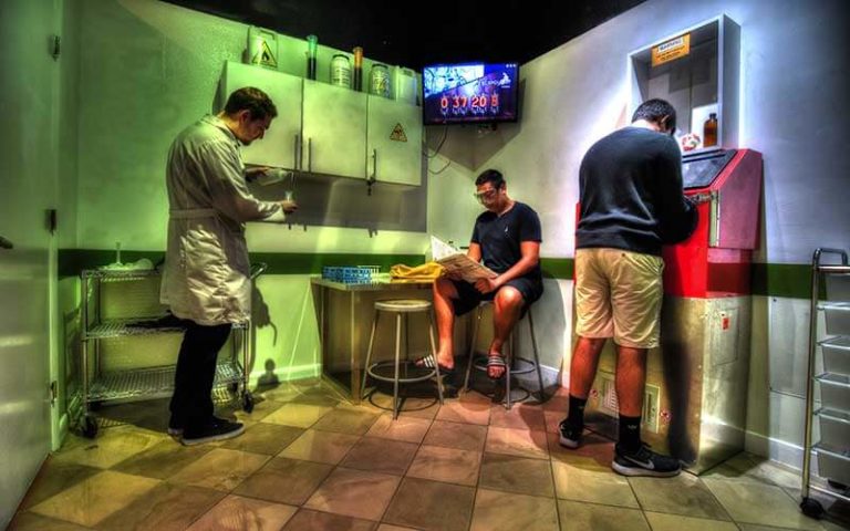 three men in a science lab themed room using equipment at escapology