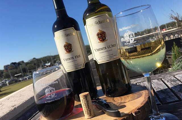 two bottles with glasses of white and red wine at san sebastian winery st augustine