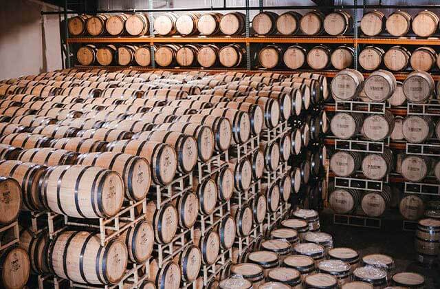 a warehouse filled with barrels on cask racks at st augustine distillery