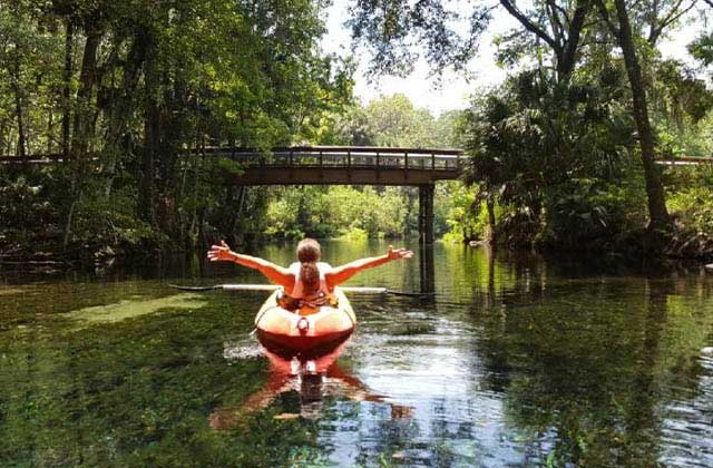 woman kayaking in river under bridge at silver springs state park ocala