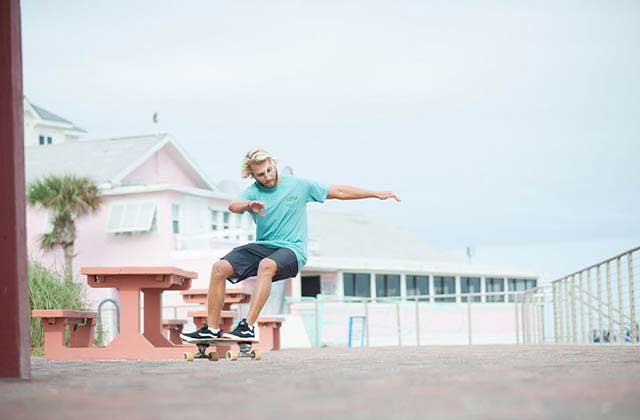 young man skateboarding on a street for ron jon surf shop panama city
