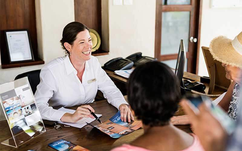 smiling woman shows two people a map