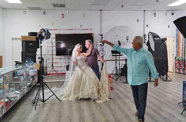 man dancing with woman in a wedding gown for photo shoot in a studio at avc photo store school miami