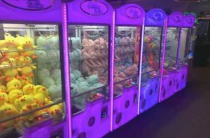 row of six claw games with stuffed animal toy prizes at fun games arcade kissimmee