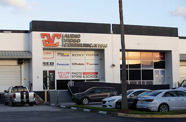 storefront with signs and vehicle parking at avc photo store and school