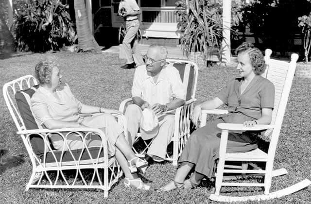 historic black and white photo of truman seated with two women in lawn chairs at harry s truman little white house key west