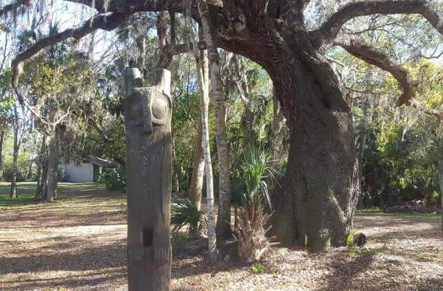 owl totem pole in the forest under oak trees with spanish moss at hontoon island state park deland florida