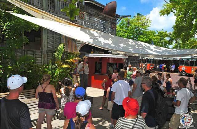 a tour group listens to guide outside front exterior at shipwreck museum key west