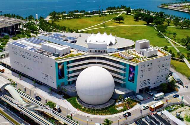 aerial exterior of museum building with globe train station and shoreline at frost science museum miami