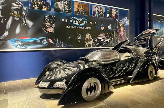 batmobile with silver wheels and fins with batman film mural at orlando auto museum dezerland
