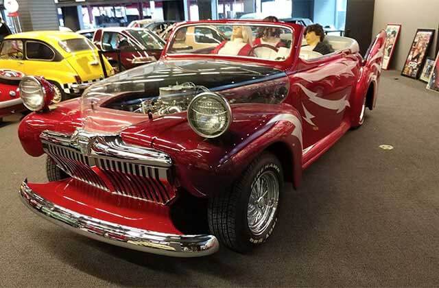 red classic car with see-through hood and other cars in the background at orlando auto museum dezerland