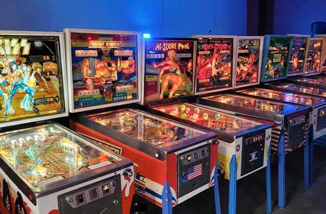 row of classic pinball games in a blue arcade at dezerland park orlando