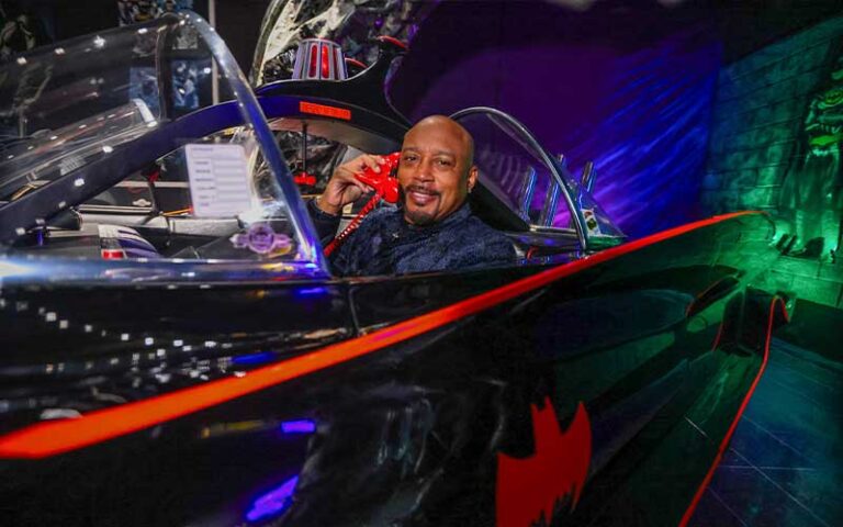 smiling man in batmobile exhibit at orlando auto museum dezerland park orlando
