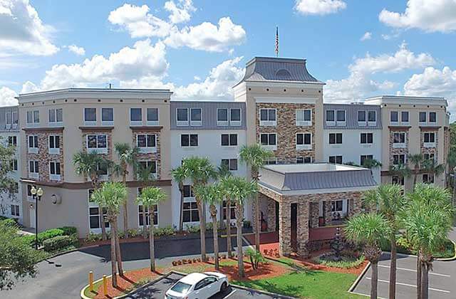 aerial view of front exterior of hotel with palm trees and parking at staybridge suites orlando royale parc suites
