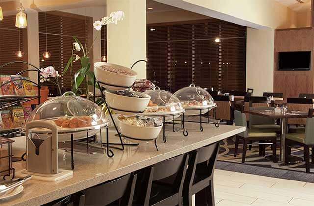 breakfast buffet counter with dining area at hilton garden inn orlando airport