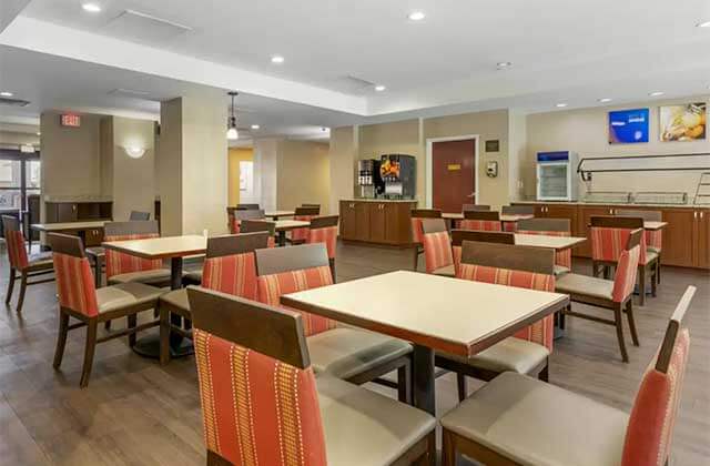 breakfast dining area with buffet tables and orange striped chairs at comfort inn international drive orlando