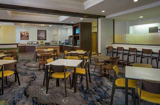 breakfast and dining area with yellow chairs and tables at fairfield inn and suites orlando lake buena vista