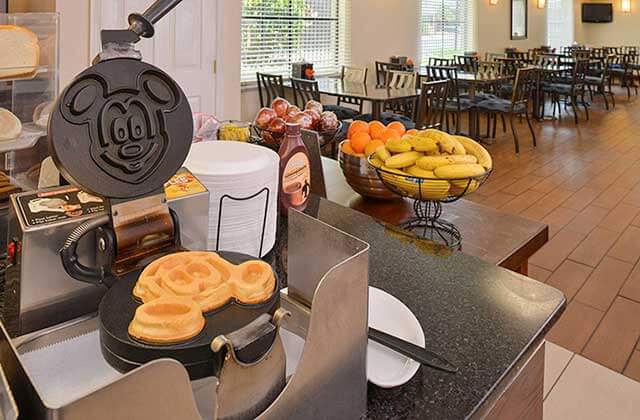 breakfast buffet area with fruit and mickey mouse waffle maker at best western international drive orlando