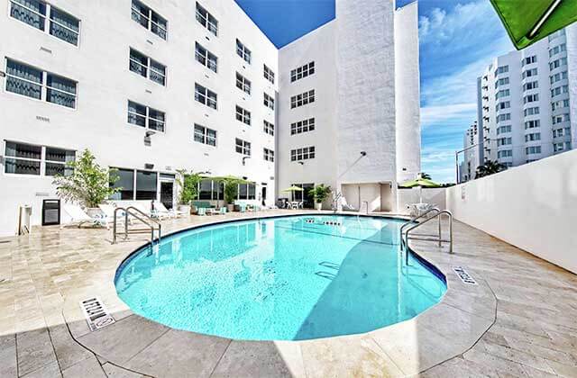 bright blue pool with green umbrella at hampton inn miami beach mid beach