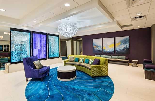 chic lobby with green and blue seating and chandelier at homewood suites by hilton orlando nearest to universal studios