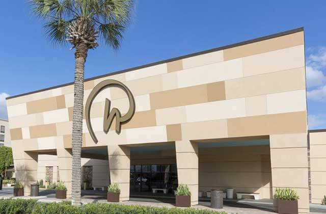 conference center entrance with logo and palm tree at rosen inn international
