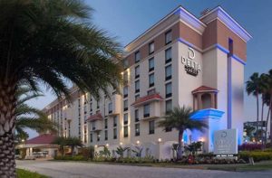 front exterior of high rise hotel at twilight at delta hotels orlando lake buena vista