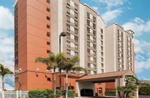 front exterior of high rise hotel with palm trees at holiday inn express and suites nearest universal orlando