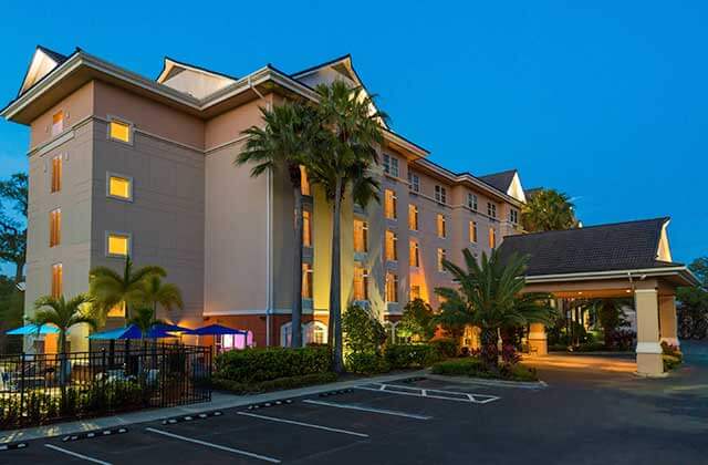 front exterior of hotel at night with palm trees at fairfield inn and suites clearwater