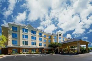 front exterior of hotel with yellow accents at comfort suites near universal orlando resort