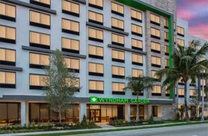 front exterior at twilight of downtown hotel with green accents and palms at wyndham garden ft lauderdale airport and cruise port