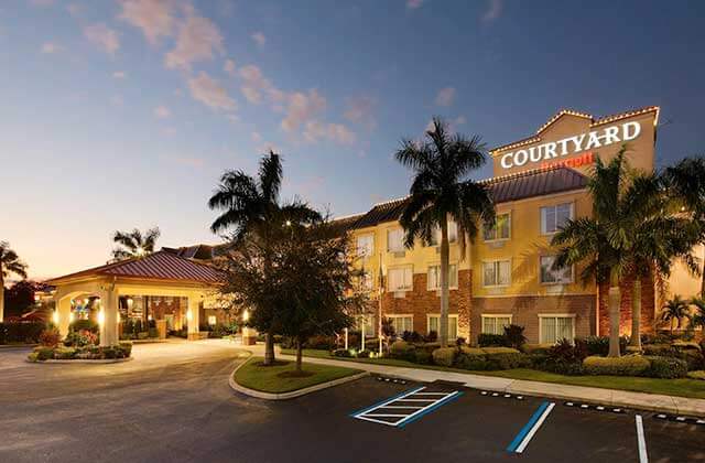 front exterior at twilight of hotel with palm trees at courtyard sarasota university park lakewood ranch area