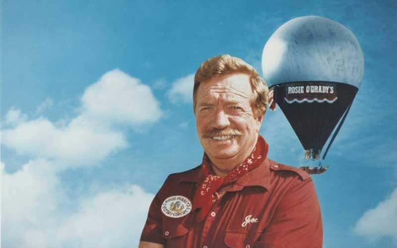 photo of Joe Kittinger in front of a light blue background with a blue hot air balloon in the background