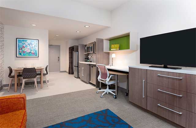 hotel room suite with kitchenette and dining area at home2 suites by hilton orlando near universal