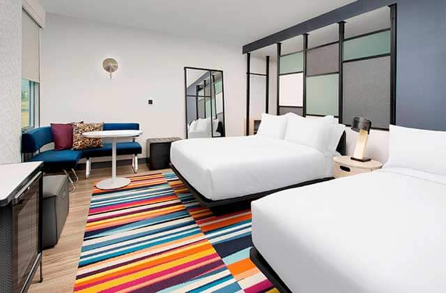 hotel room with colorful carpet and two beds at aloft orlando international drive