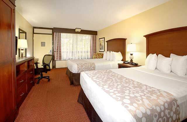 hotel room with dark red decor and two beds at rosen inn lake buena vista