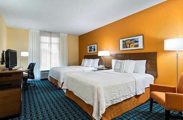hotel room with two large beds and orange and blue accents at fairfield inn and suites clearwater