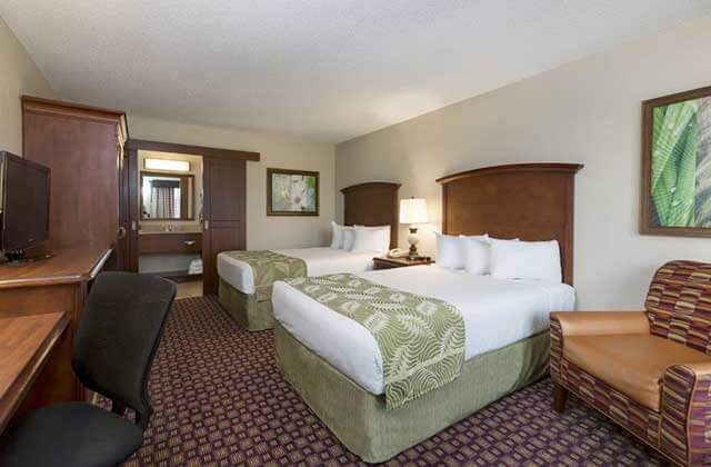 hotel room with two large beds with green accents at rosen inn at pointe orlando
