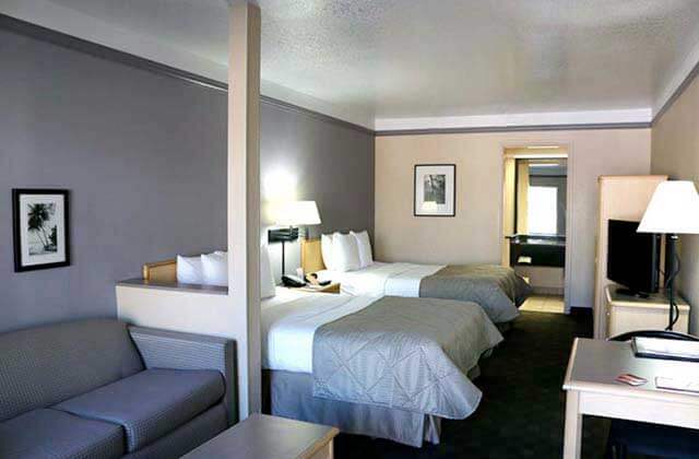 hotel room with two queen size beds and sofa at clarion suites maingate