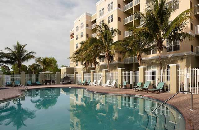 huge pool area with blue lounge chairs and palms at residence inn fort myers sanibel
