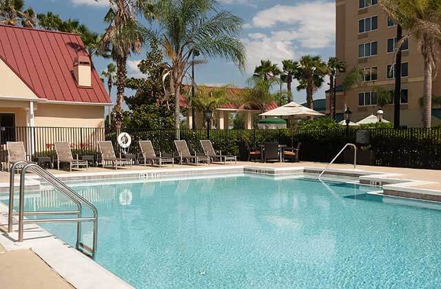 large swimming pool with lounge chairs at residence inn by marriott orlando convention center
