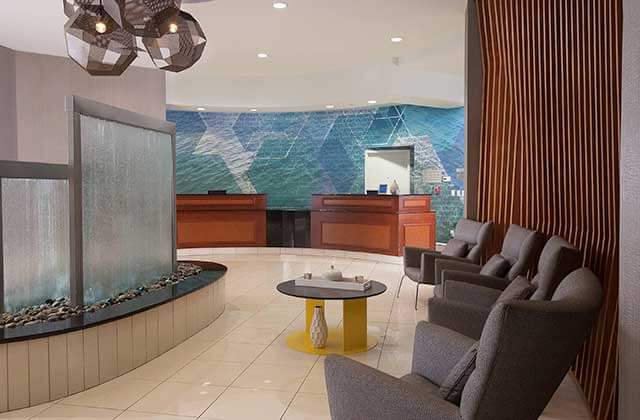 lobby and front desk with waterfall feature at springhill suites orlando airport
