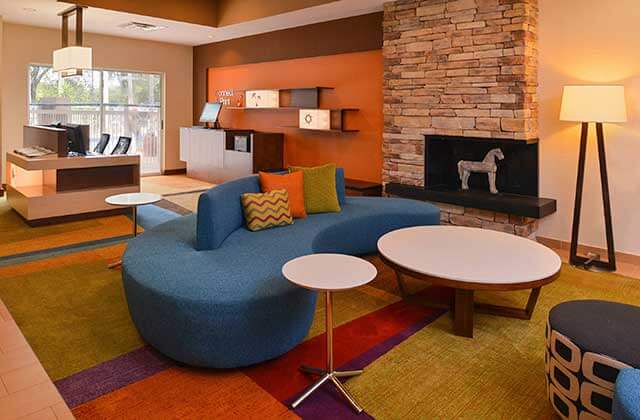 lobby area with blue sofa fireplace and business center at fairfield inn orlando airport