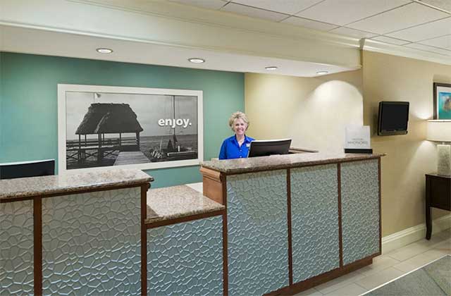 lobby front desk with lady smiling and teal accent wall at hampton inn ellenton bradenton florida