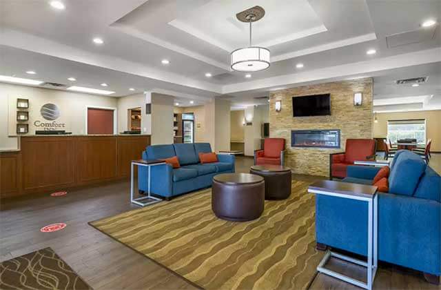 lobby with front desk blue sofas and fireplace at comfort inn international drive orlando