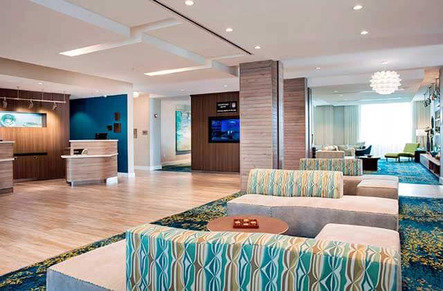 lobby with front desk in caribbean colors and lounge seating at courtyard marathon florida keys