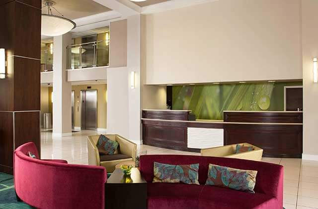lobby with front desk vaulted ceiling and red sofas at springhill suites fort lauderdale airport and cruise port