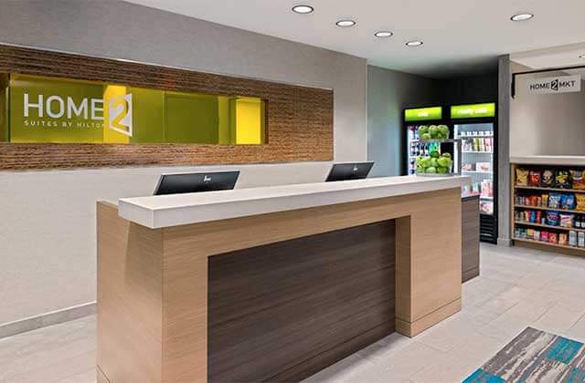 lobby with reception desk and market snack area at home2 suites by hilton orlando near ucf